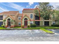 Charming two-story condo featuring tile roofing and lush landscaping at 445 Fountainhead Cir # 262, Kissimmee, FL 34741