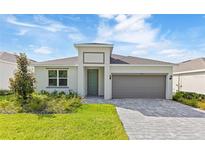 Charming single-story home with a gray garage door and a well-manicured front yard at 797 Lemon Ave, Fruitland Park, FL 34731