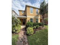 Inviting two-story home with a covered porch, lush landscaping, and a well-maintained lawn at 15208 Avenue Of The Arbors, Winter Garden, FL 34787