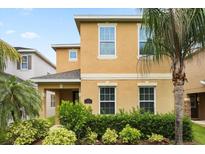 Charming two-story home with a well-manicured lawn and lush tropical landscaping at 15208 Avenue Of The Arbors, Winter Garden, FL 34787