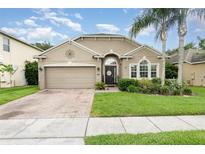 Charming single-story home boasts manicured lawn, mature landscaping, and a brick-paved driveway at 15606 Montesino Dr, Orlando, FL 32828