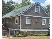 Charming home featuring gray siding, a green roof, and a decorative sun accent at 1717 Se 190Th Ave, Silver Springs, FL 34488