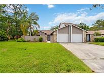 Charming home featuring attached garage, and a beautifully maintained green lawn at 244 Surf Scooter Dr, Daytona Beach, FL 32119
