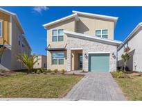 Charming two-story home boasts stone accents, a modern design, and a well-manicured front yard at 2924 Protagonist St, Kissimmee, FL 34746