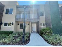 Charming two-story home featuring a balcony, stucco facade, and well-maintained landscaping at 3235 Brasilia Ave, Kissimmee, FL 34747