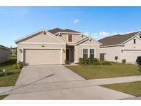 Charming single-story home with a well-maintained lawn, attached garage, and neutral color palette at 4223 Little Owl Ln, Kissimmee, FL 34746
