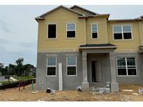 Unfinished exterior with yellow siding, grey base, and windows on a sunny day at 551 Pothos St, Apopka, FL 32703