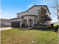 Beautiful two-story home with a stone-accented entryway, manicured lawn, and two-car garage at 5550 Sabal Dr, St Cloud, FL 34771