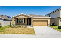 Charming single-story home with a well-maintained lawn and a two-car garage at 716 Daring Dr, Davenport, FL 33837