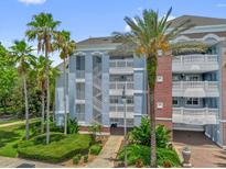 A beautiful blue building with balconies and palm trees in a tropical community at 7613 Cabana Ct # 102, Reunion, FL 34747