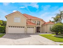 Stunning two-story home featuring a three-car garage, tile roof, and a lush, green lawn at 9062 Dancy Tree Ct, Orlando, FL 32836