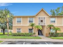 Charming condo exterior with tan walls, palm trees and manicured landscaping, and a blue sky at 9900 Sweepstakes Ln # 1, Orlando, FL 32837