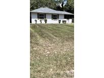 Charming single story home with tidy landscaping, brown shutters and a grey roof at 1030 Nw 13Th Ave, Ocala, FL 34475