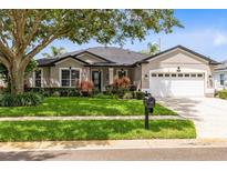 Charming single-story home with a well-manicured lawn and mature landscaping at 1154 Kerwood Cir, Oviedo, FL 32765