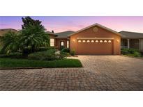 Charming home featuring a brick driveway, two-car garage, and lush landscaping creating great curb appeal at 118 Ventana Dr, Kissimmee, FL 34759