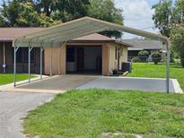 Spacious carport with concrete driveway and attached garage provides ample parking and protection from the elements at 1335 Cr 442, Lake Panasoffkee, FL 33538