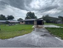 Charming single-story home featuring carport, lush lawn, and inviting curb appeal at 1335 Cr 442, Lake Panasoffkee, FL 33538