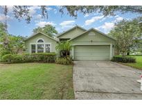 Charming single-story home featuring a two-car garage and lovely, low-maintenance landscaping at 16103 Denham Ct, Clermont, FL 34711