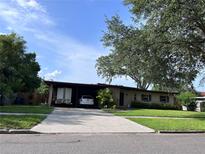 Charming single-story home featuring an attached carport and a well-manicured front lawn at 1901 Loch Berry Rd, Winter Park, FL 32792