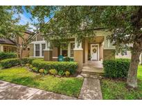 Charming home featuring a covered porch, lush landscaping, and a welcoming entrance with a white front door at 2246 Florida Soapberry Blvd, Orlando, FL 32828