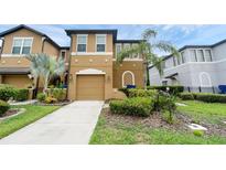 Charming townhome featuring a two-car garage, manicured landscaping, and a welcoming front entrance at 2502 Seven Oaks Dr, St Cloud, FL 34772