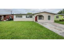 Charming single-story home featuring a red front door, well-maintained lawn, and inviting curb appeal at 26 Channing Ave, Orlando, FL 32811