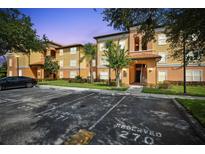 Inviting condo building with colorful facade, lush landscaping, and reserved parking spaces, creating an appealing curb appeal at 5467 Vineland Rd # 6110, Orlando, FL 32811
