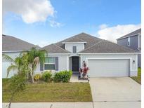 Charming single-story home featuring a well-manicured lawn, two-car garage, and freshly painted exterior at 554 Pawnee Ct, Haines City, FL 33844