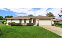 Charming single-story home boasts a manicured lawn and mature landscaping, enhancing its curb appeal at 8988 Angelica Dr, Orlando, FL 32836