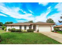Charming single-story home with a well-maintained lawn and attached two-car garage at 8988 Angelica Dr, Orlando, FL 32836