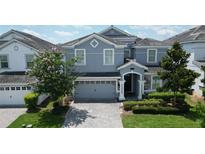 Charming two-story home with a well-manicured lawn and beautiful landscaping at 9014 Stinger Dr, Davenport, FL 33896