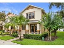 Charming two-story home with a beautifully landscaped front yard and inviting front porch seating area at 14474 Prunningwood Pl, Winter Garden, FL 34787