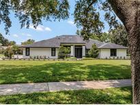 Stunning single-story home featuring a modern black and white design and lush green lawn at 4454 Aspenwood Ct, Orlando, FL 32835