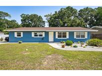 Charming blue single-story home featuring a well-manicured lawn and inviting curb appeal at 6663 Nw 60Th St, Ocala, FL 34482