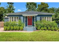 Charming single-story home with a red front door, lush landscaping, and a well-manicured lawn at 725 S Hampton Ave, Orlando, FL 32803