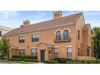 Charming two-story home with tile roof, green door, manicured landscaping, and stucco siding at 730 Siena Palm Dr # 201, Celebration, FL 34747