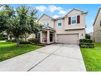 Charming two-story home with a manicured lawn, a two-car garage, and beautiful landscaping at 750 Maple Leaf Loop, Winter Springs, FL 32708
