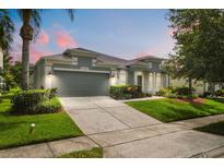 Charming single-story home featuring a well-manicured lawn and gray two-car garage and coordinated trim at 14016 Fox Glove St, Winter Garden, FL 34787