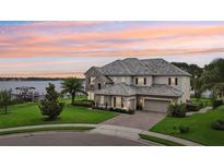 Stunning two-story waterfront home with meticulous landscaping and a paver driveway at 15779 Tangerine Dream Ct, Winter Garden, FL 34787