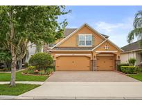 Charming two-story home with a brick driveway, two-car garage, and manicured landscaping at 1613 Water Elm Ct, Orlando, FL 32825