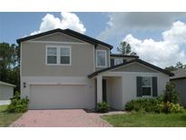 Two-story home featuring a brick driveway, two car garage, and manicured front yard at 17305 Cagan Crossings Blvd, Clermont, FL 34714