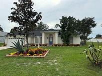Charming single-story home featuring a well-manicured lawn and tasteful landscaping with colorful flowerbeds at 2864 Trenton Ln, Deltona, FL 32738