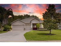 Well-maintained single-story home with a three-car garage, landscaped yard, and inviting front entrance at 3281 Saloman Ln, Clermont, FL 34711
