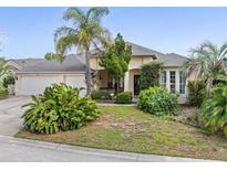 Inviting single-story home featuring a well-manicured lawn and lush tropical landscaping at 407 Grand Reserve Dr, Davenport, FL 33837