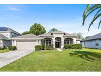 Charming single-story home featuring a well-manicured lawn and a two-car garage at 610 Strihal Loop, Oakland, FL 34787