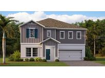 Charming two-story home with a gray facade, white trim, and a well-manicured front lawn at 695 Peroni Ave, Debary, FL 32713