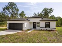 Charming single-story home featuring a two-car garage and freshly landscaped front yard at 706 Marion Oaks Manor, Ocala, FL 34473