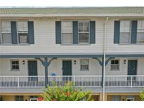 Charming two-story condo featuring a lovely porch and blue trim on the windows and supports at 720 Celebration Ave # 245, Kissimmee, FL 34747