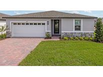 Charming single-Gathering home with a well-manicured lawn, a brick driveway and a two-car garage at 1345 Griffon Ave, Lake Alfred, FL 33850