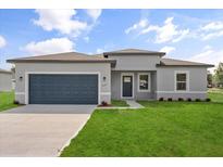 Charming single-story home featuring a well-manicured lawn and a two-car garage, perfect for Gathering living at 14915 Sw 39Th Cir, Ocala, FL 34473